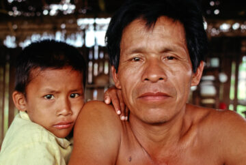 A father and his son in their hut in the Peruvian Amazon