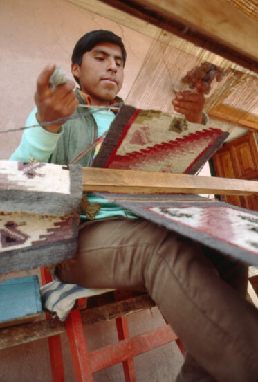 Boy weaving textiles in Cusco, Peru