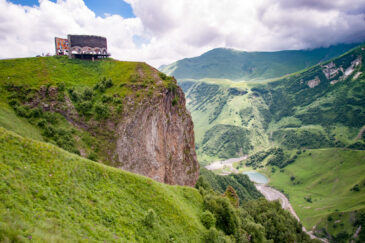 The Treaty of Georgievsk Monument is located along the Georgian Military Highway between the ski resort town of Gudauri and the Jvari Pass in northern Georgia, near the Russian border. This striking circular stone and concrete structure was erected in 1983 to commemorate the bicentennial of the 1783 Treaty of Georgievsk, which established eastern Georgia as a protectorate of the Russian Empire.
Perched on a cliff overlooking the Devil's Valley in the Caucasus Mountains, the monument offers breathtaking panoramic views of the surrounding landscape. Inside, a vibrant tile mural spans the entire circumference, depicting scenes from Georgian and Russian history, including heroes, farmers, fairy tales, and communist symbols
