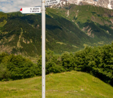 Hiking trail marker outside of Mestia, Svaneti, Georgia. Mt Ushba, known as the "Matterhorn of the Caucasus" for its double summit, is seen in the background.