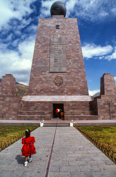 A young girl walk the center line of the Middle of the Earth monument near Quito, Equador.
